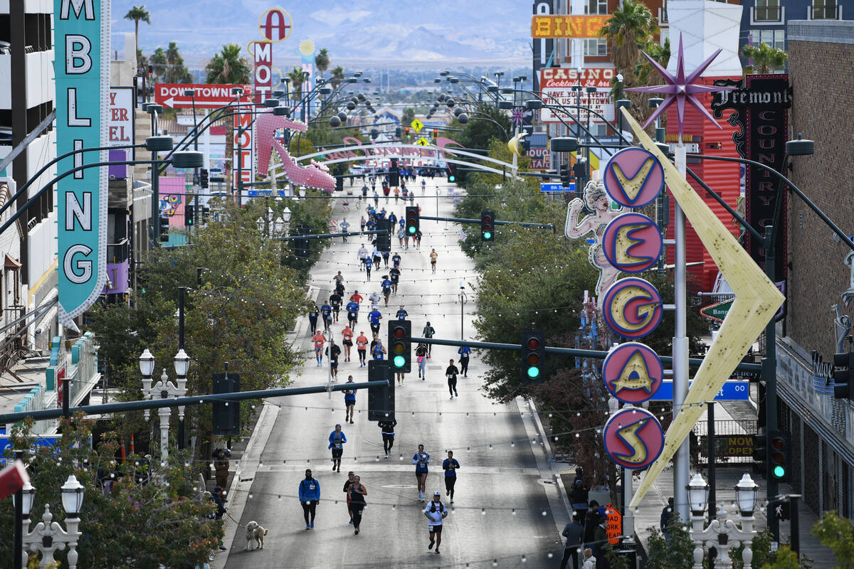 Participants head towards the finish line on Fremont Street during the 2024 Las Vegas Marathon. ...