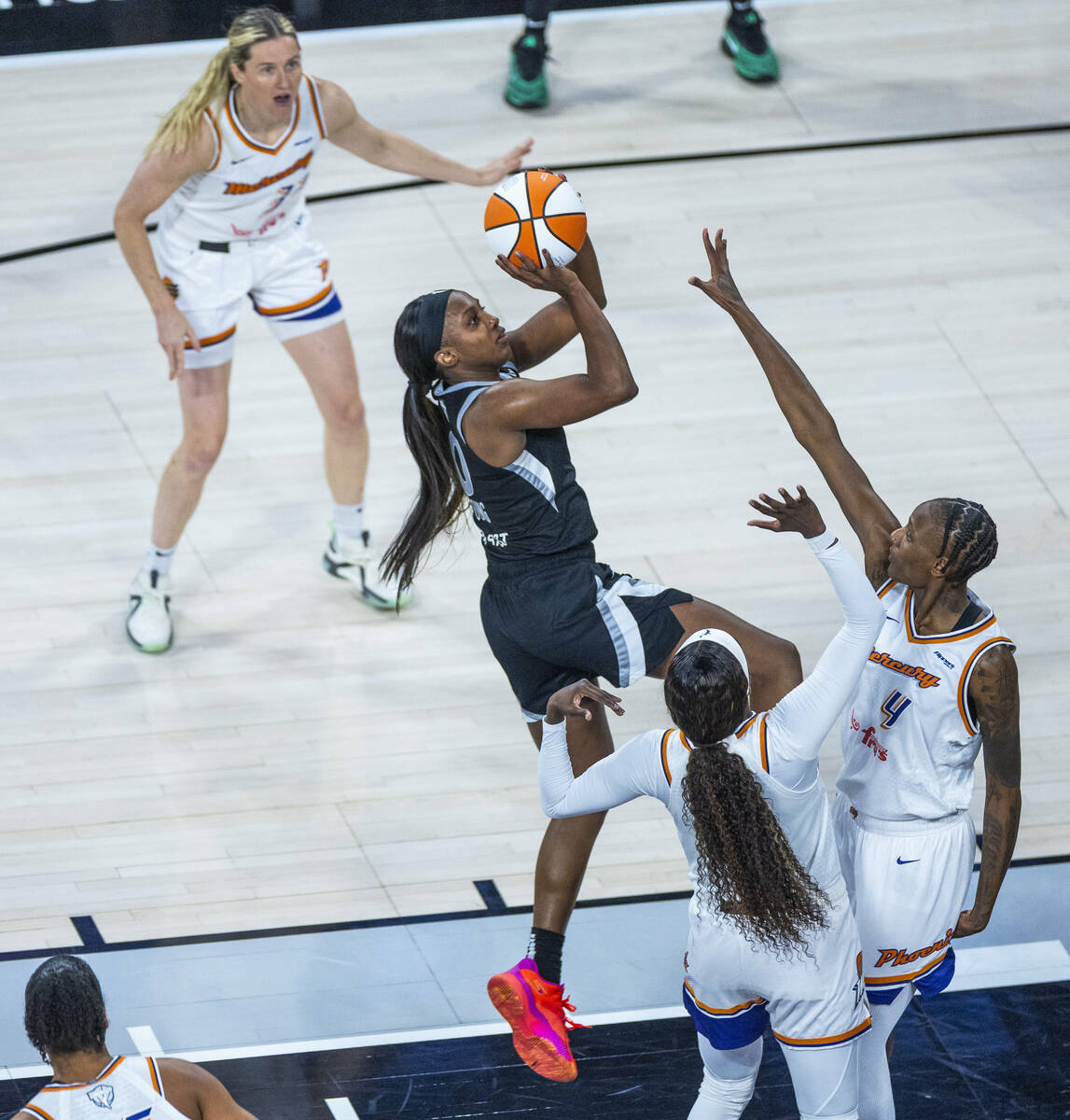 Aces guard Jackie Young (0) elevates to get a shot over Phoenix Mercury forward Natasha Mack (4 ...