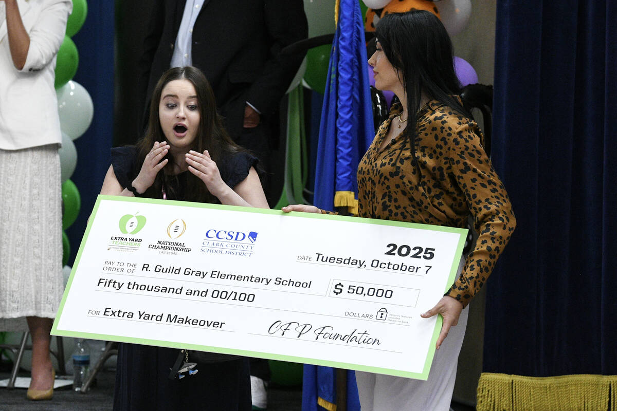 School librarian Claire Yates reacts as she receives a $50,000 donation for her library during ...