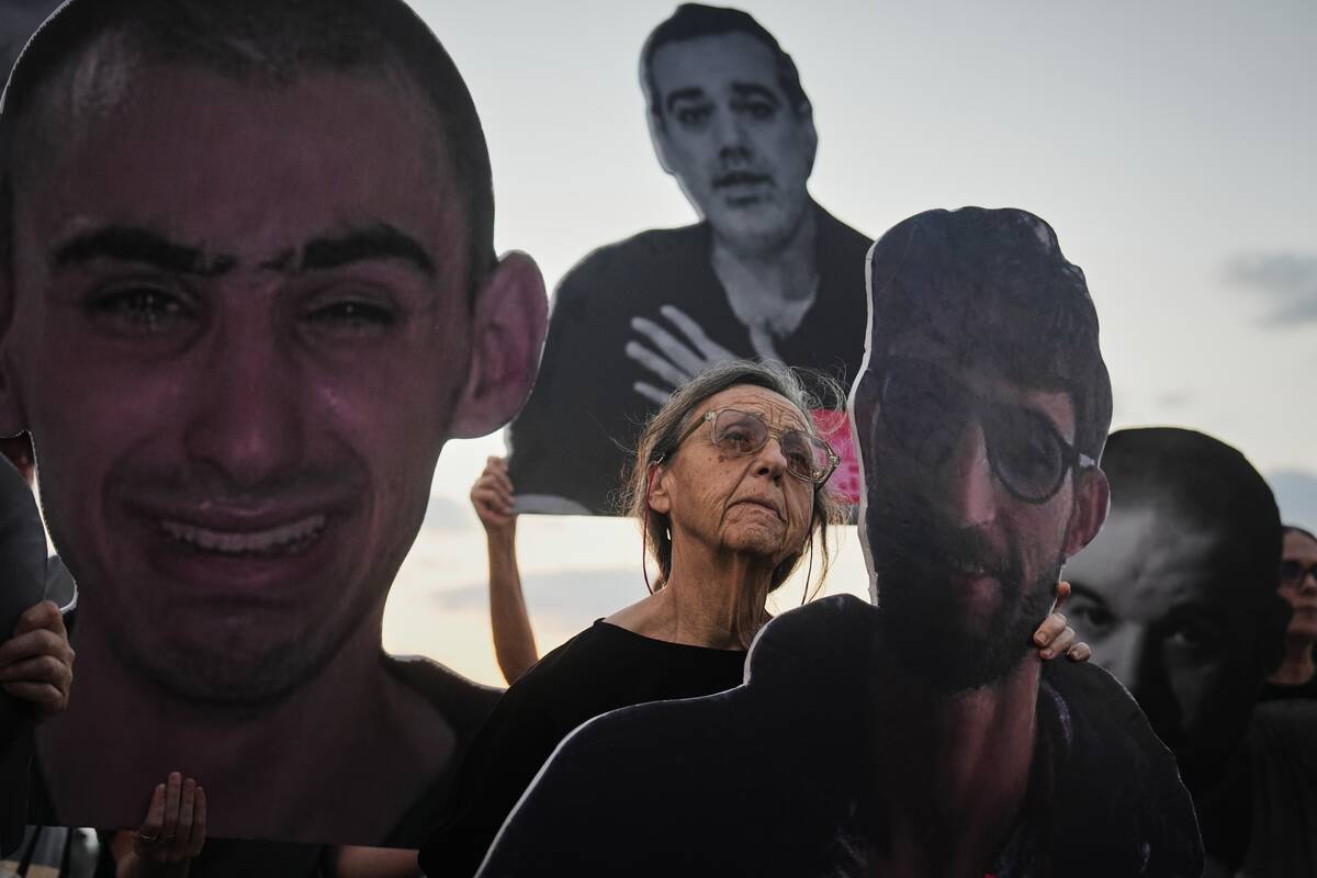 Demonstrators hold photos depicting the faces of Israeli hostages who are being held in the Gaz ...