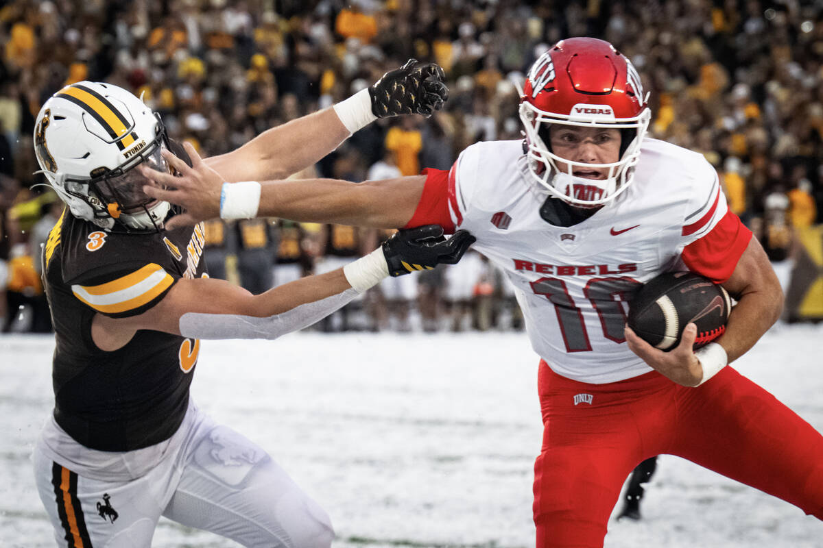 UNLV quarterback Anthony Colandrea stiff arms University of Wyoming safety Andrew Johnson durin ...