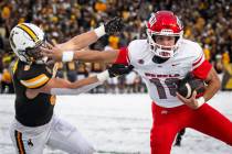 UNLV quarterback Anthony Colandrea stiff arms University of Wyoming safety Andrew Johnson durin ...