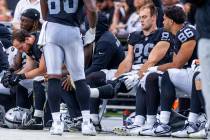 Raiders tight end Brock Bowers (89) checks his knee while on the bench with teammates against t ...