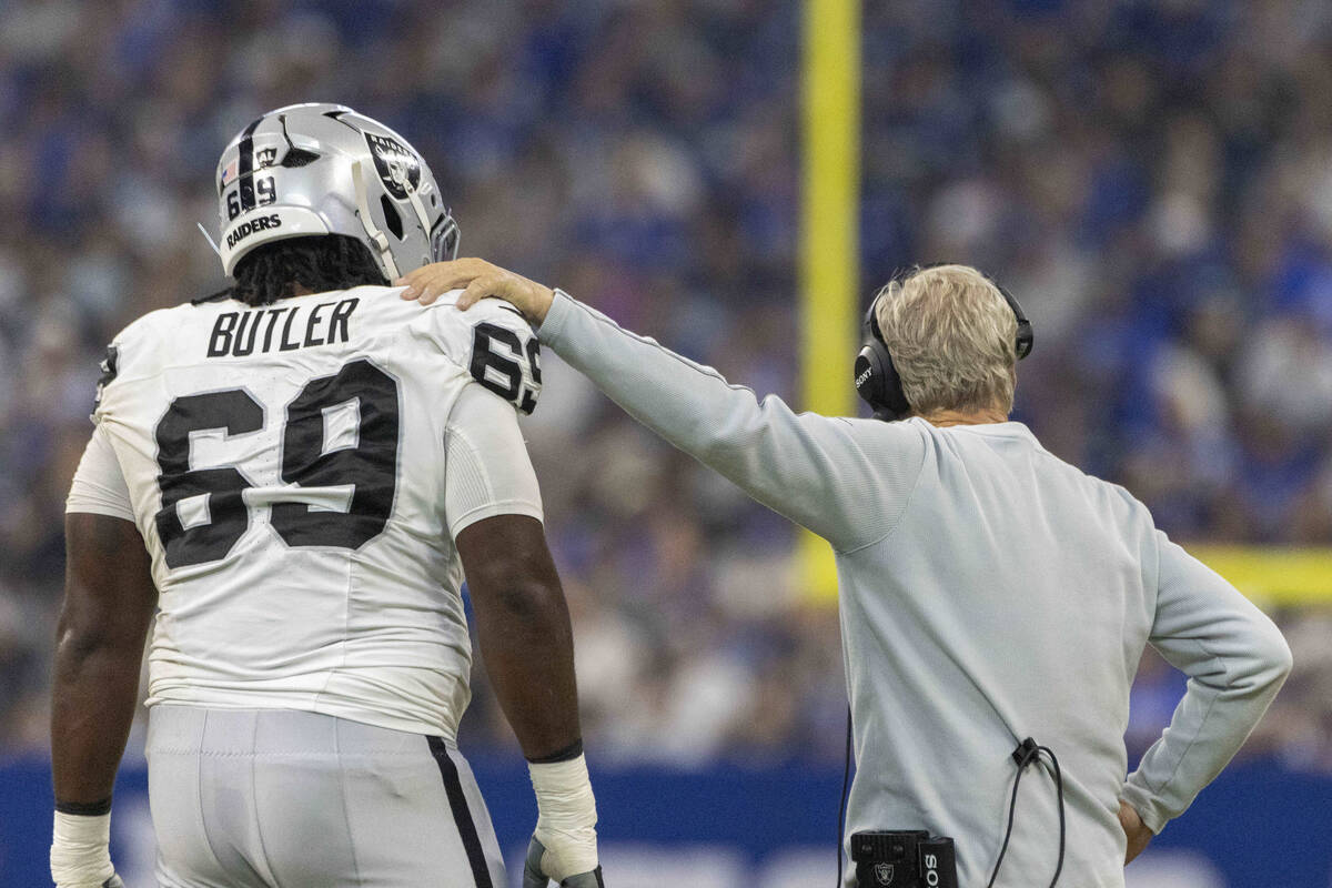 Raiders head coach Pete Carroll meets with Raiders defensive tackle Adam Butler (69) during a t ...