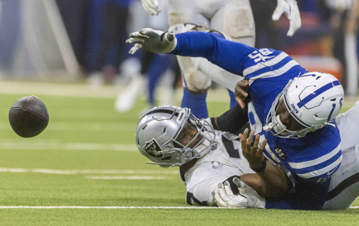 Indianapolis Colts defensive tackle Adetomiwa Adebawore (95) reaches for a loose football after ...