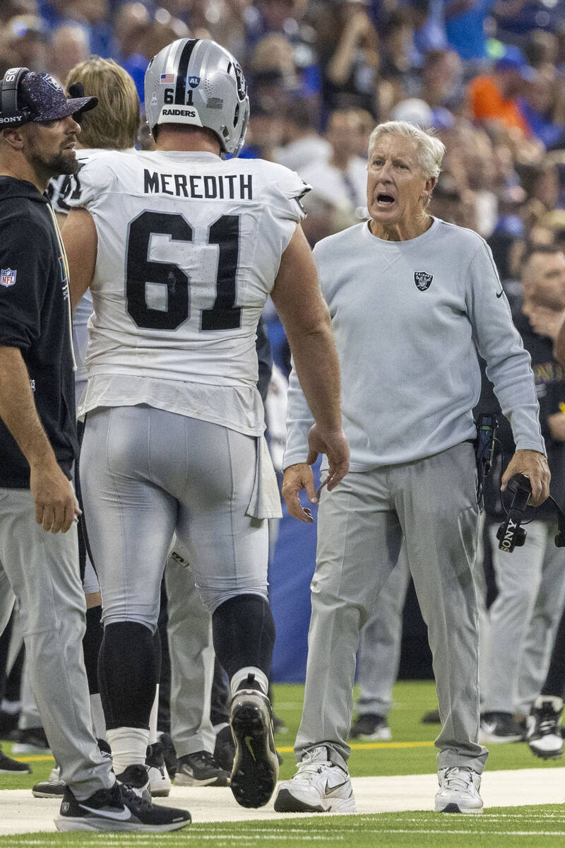 Raiders head coach Pete Carroll interacts with guard Jordan Meredith (61) as he returns to the ...