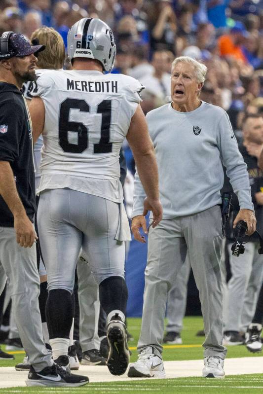 Raiders head coach Pete Carroll interacts with guard Jordan Meredith (61) as he returns to the ...
