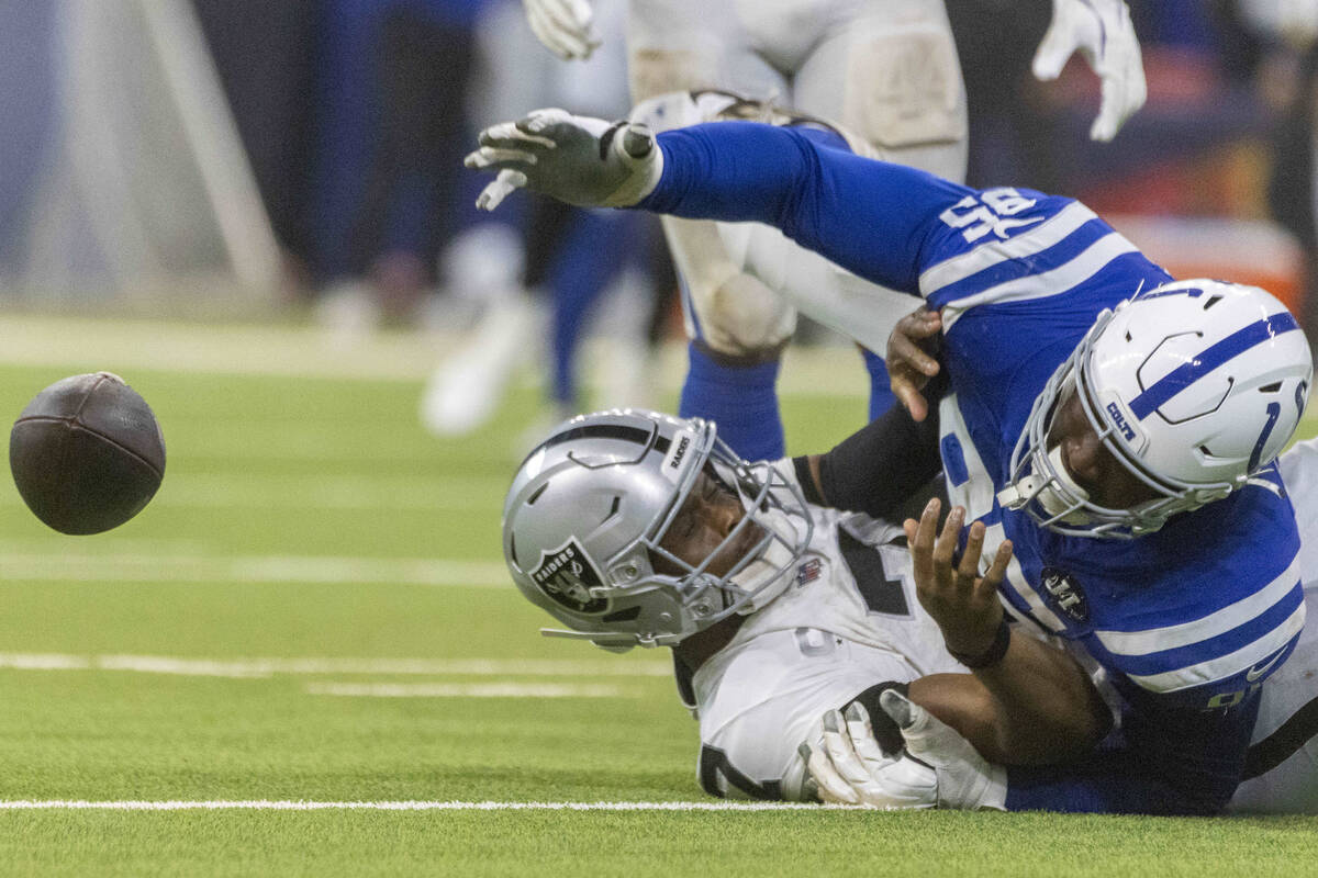 Indianapolis Colts defensive tackle Adetomiwa Adebawore (95) reaches for a loose football after ...