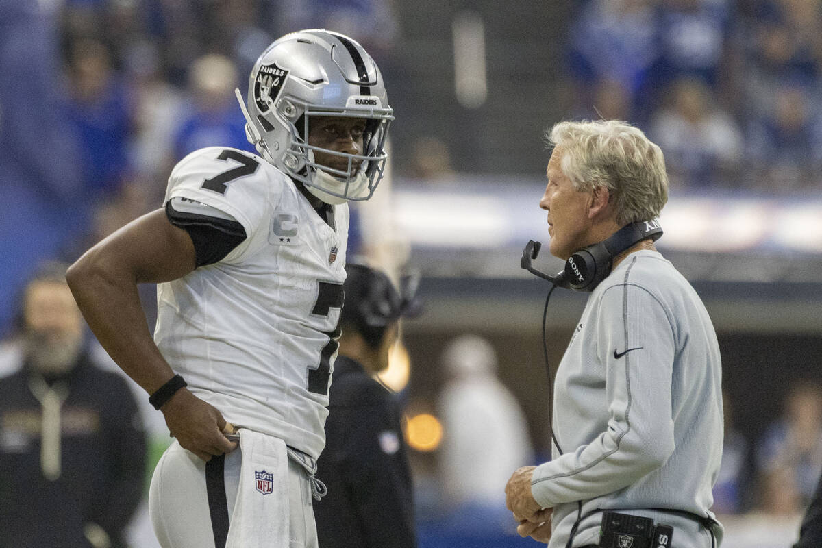 Raiders head coach Pete Carroll meets with Raiders quarterback Geno Smith (7) during a timeout ...