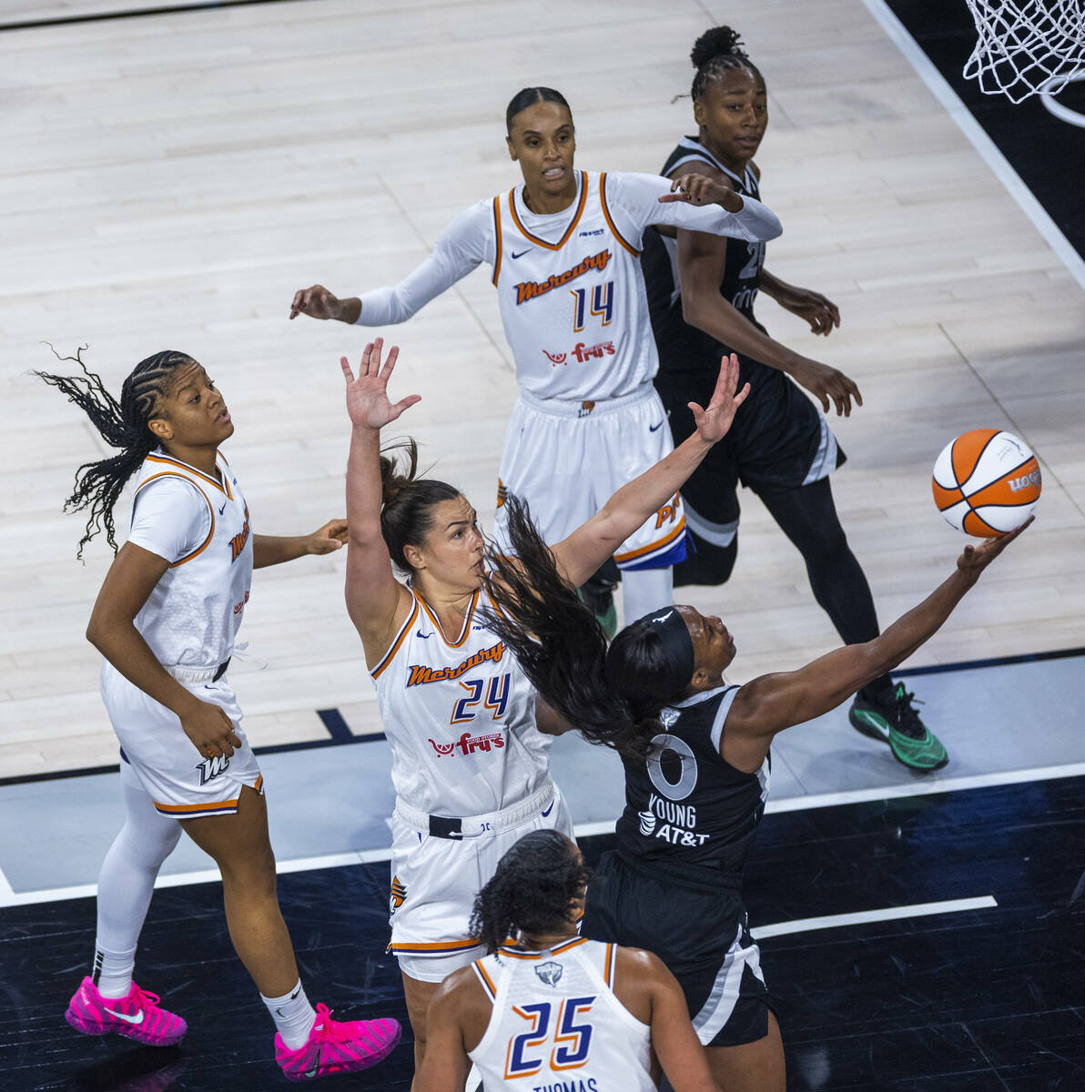 Aces guard Jackie Young (0) gets inside of Phoenix Mercury forward Kathryn Westbeld (24) for a ...