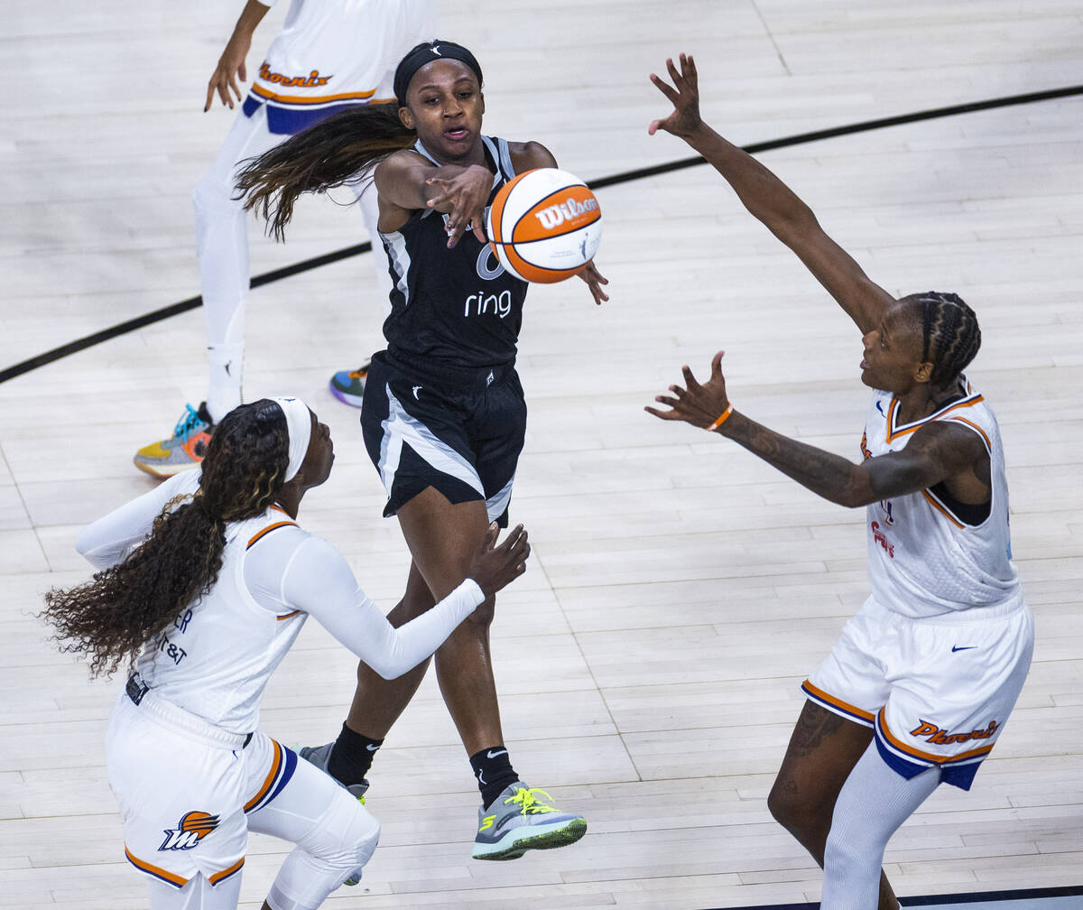 Aces guard Jackie Young (0) gets off a pass between Phoenix Mercury guard Kahleah Copper (2) an ...