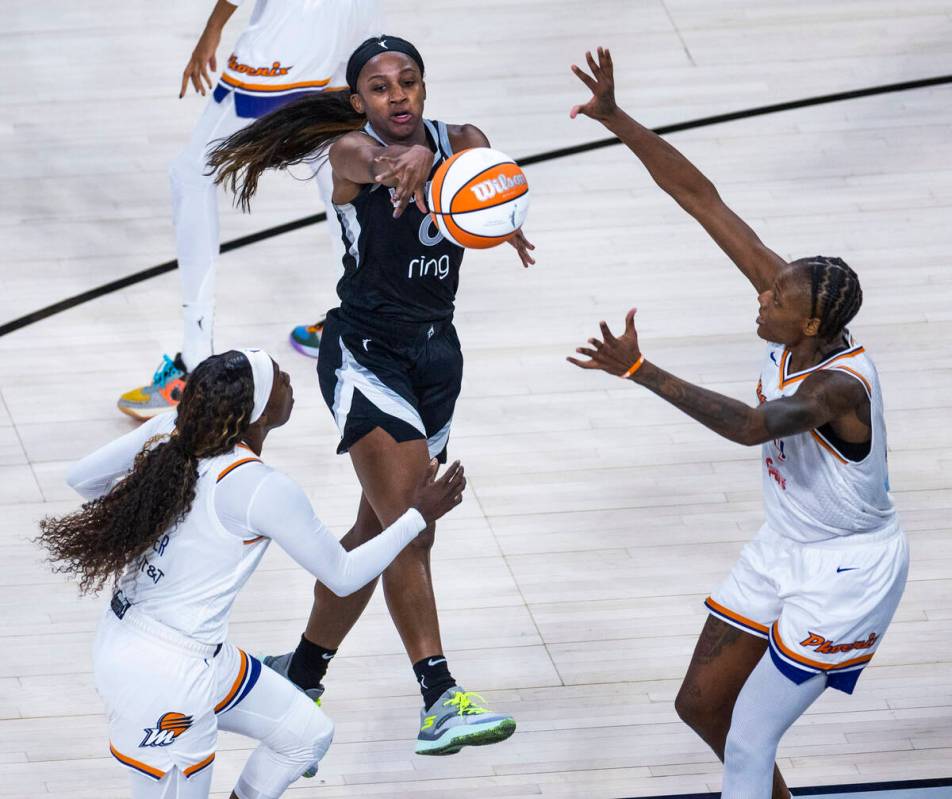Aces guard Jackie Young (0) gets off a pass between Phoenix Mercury guard Kahleah Copper (2) an ...