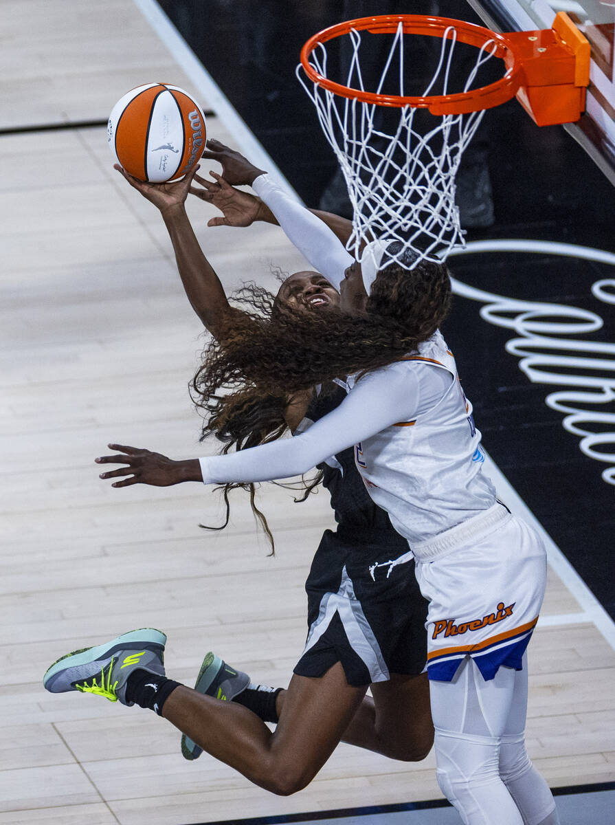 Aces guard Jackie Young (0) gets off a while fouled by Phoenix Mercury guard Kahleah Copper (2) ...