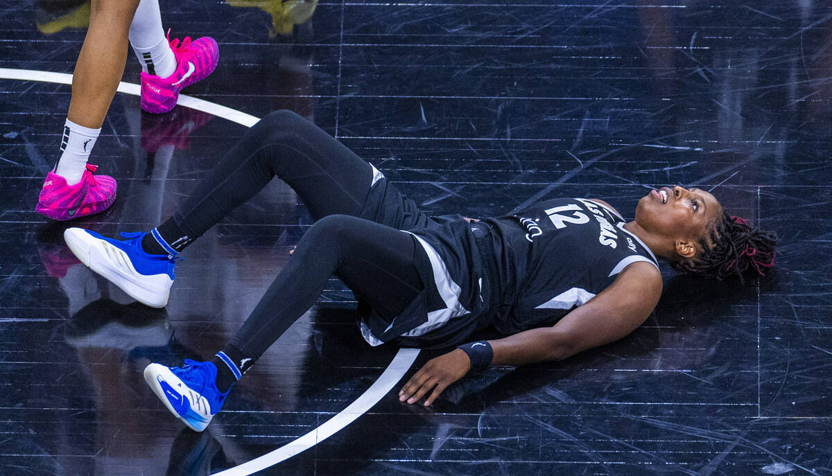 Aces guard Chelsea Gray (12) looks up from the hardwood after a collision with a Phoenix Mercu ...
