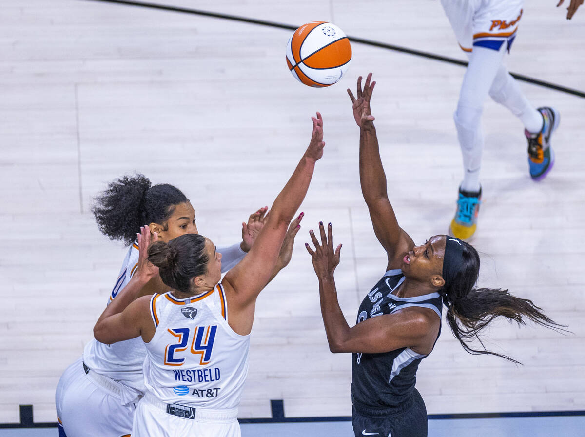 Aces guard Jackie Young (0) floats up a shot over Phoenix Mercury forward Kathryn Westbeld (24) ...