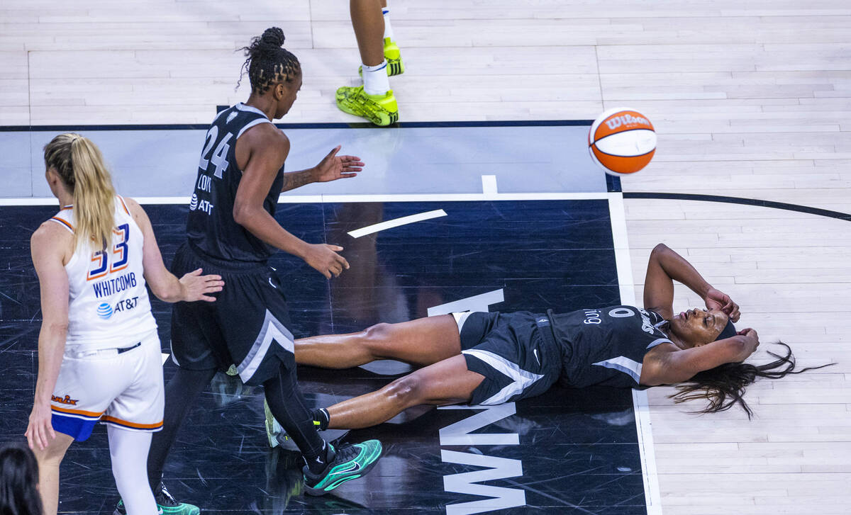 Aces guard Jackie Young (0) looks up from the hardwood after a foul from the Phoenix Mercury du ...