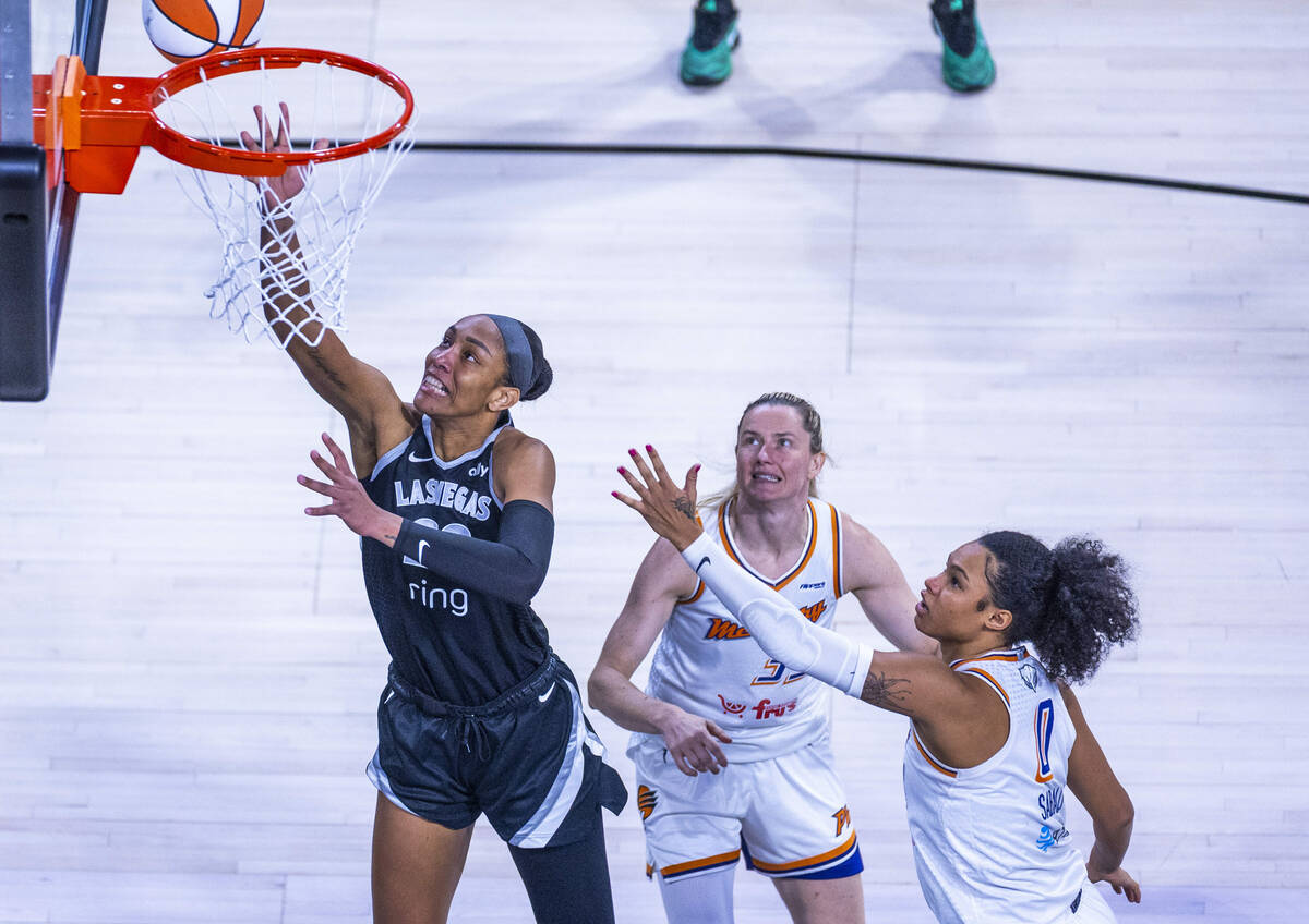 Aces center A'ja Wilson (22) lays up the ball beating Phoenix Mercury guard Sami Whitcomb ...