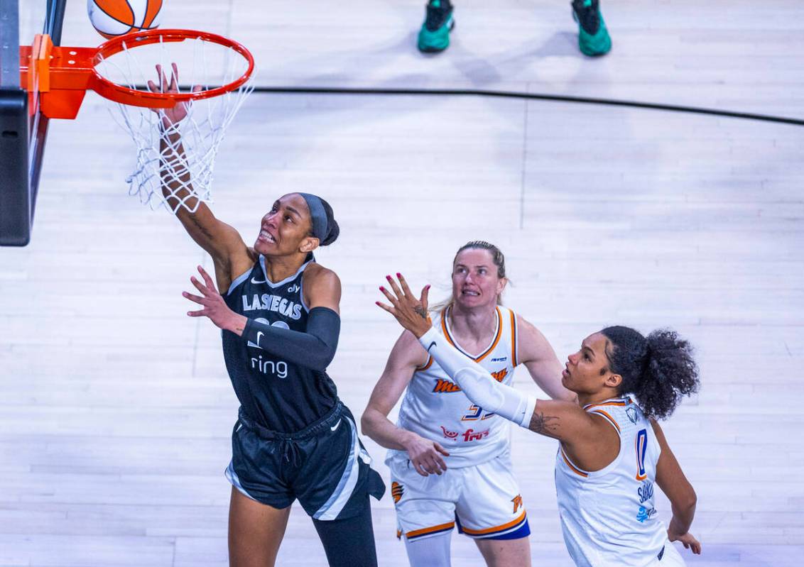 Aces center A'ja Wilson (22) lays up the ball beating Phoenix Mercury guard Sami Whitcomb ...