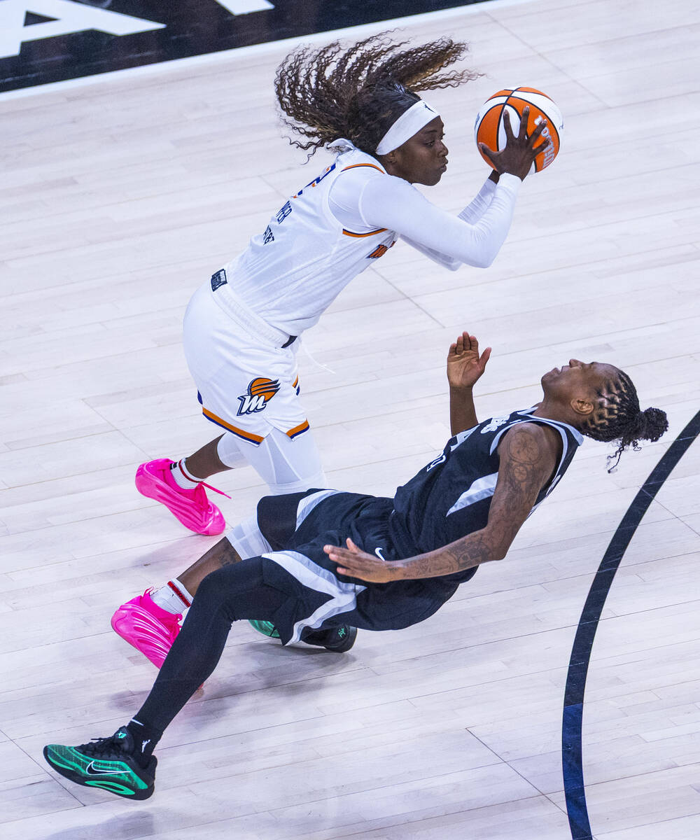 Aces guard Jewell Loyd (24) takes a hard charge to the face from Phoenix Mercury guard Kahleah ...