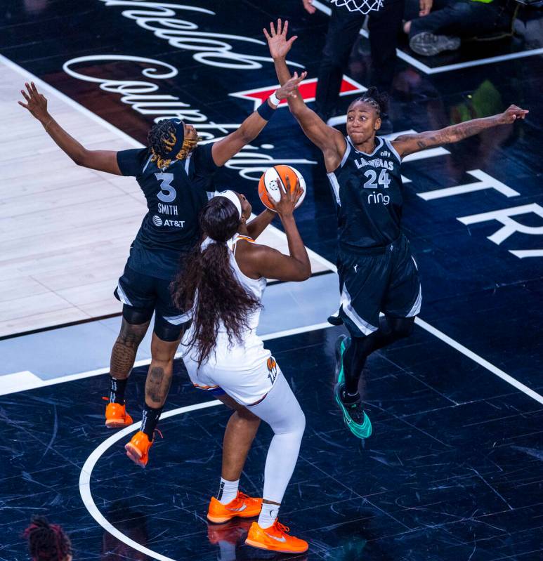 Phoenix Mercury center Kalani Brown (21) attempts to get off a shot with tight defense by Aces ...