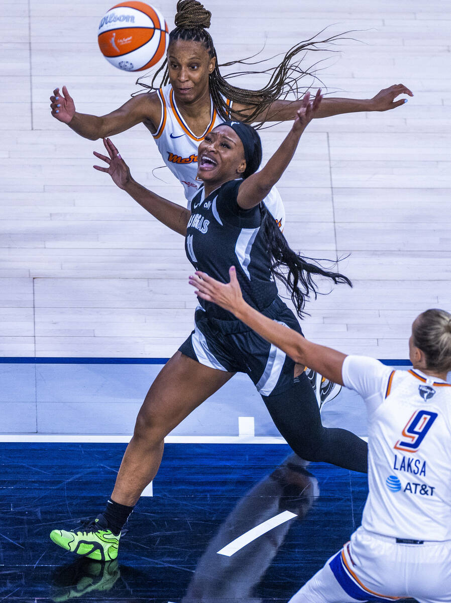 Aces guard Dana Evans (11) chases a loose ball between Phoenix Mercury guard Kiana Williams (23 ...
