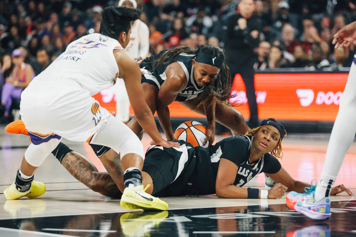 Aces guard Jackie Young (0) picks the ball up off of Aces forward NaLyssa Smith (3) during game ...