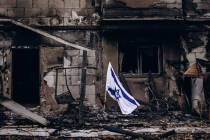 An Israeli flag flies beside a burned house in Kibbutz Be'eri. (Micha Brickman/Israel Hayom Arc ...