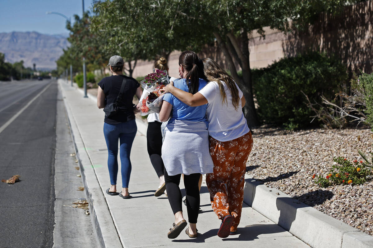 Family and friends comfort each other on West Tropical Parkway west of North Emerald Eagle Stre ...