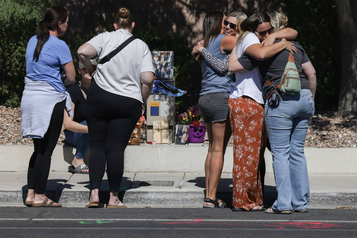 Family and friends comfort each other on West Tropical Parkway west of North Emerald Eagle Stre ...