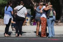 Family and friends comfort each other on West Tropical Parkway near North Emerald Eagle Street ...