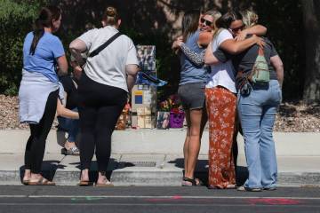 Family and friends comfort each other on West Tropical Parkway near North Emerald Eagle Street ...
