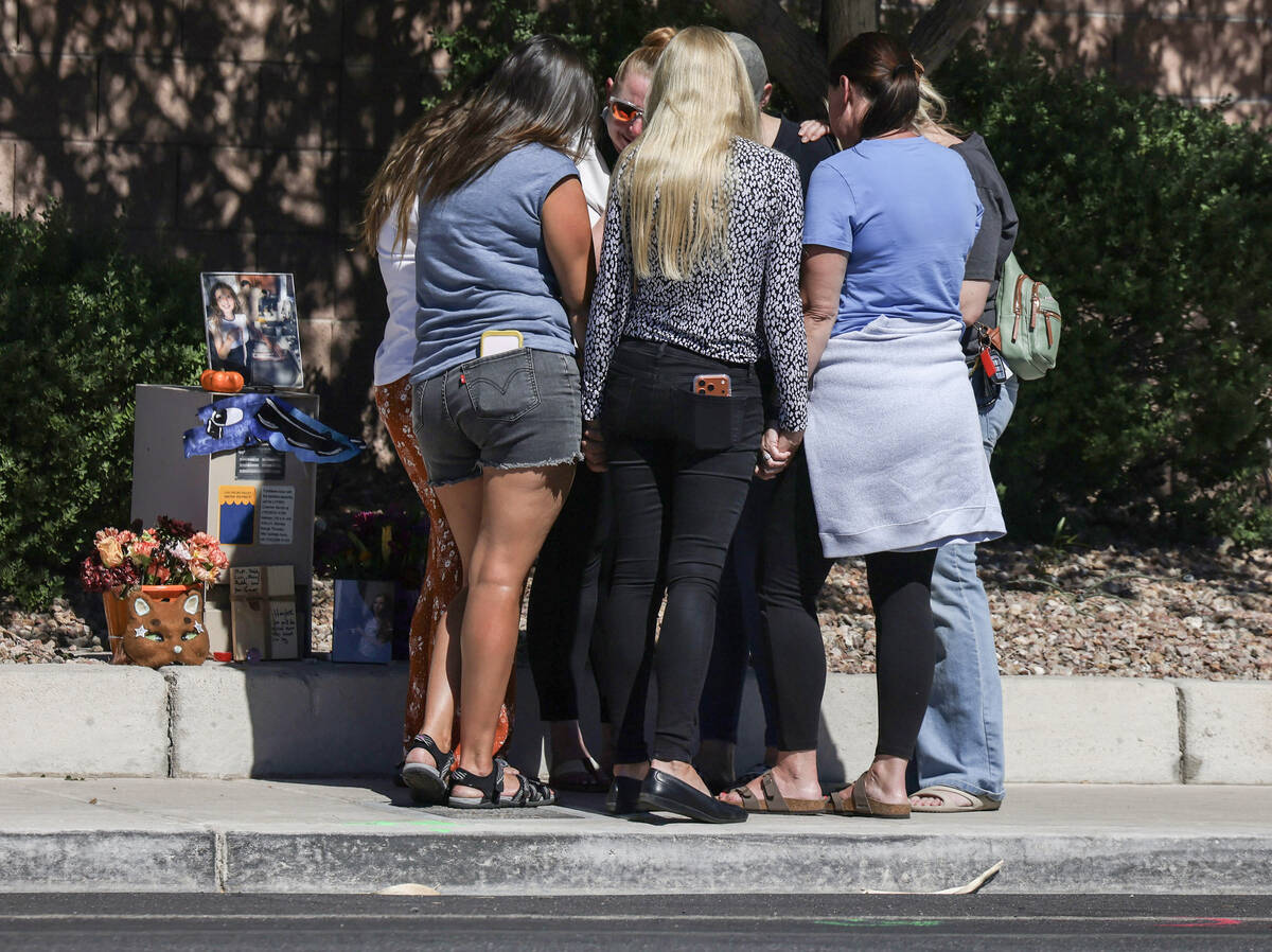 Family and friends comfort each other while praying on West Tropical Parkway west of North Emer ...