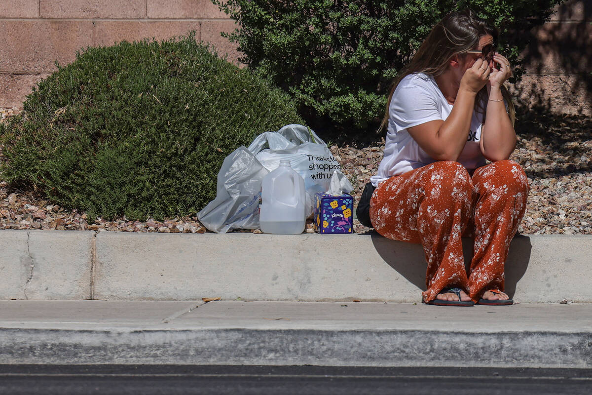 Family and friends comfort each other on West Tropical Parkway west of North Emerald Eagle Stre ...