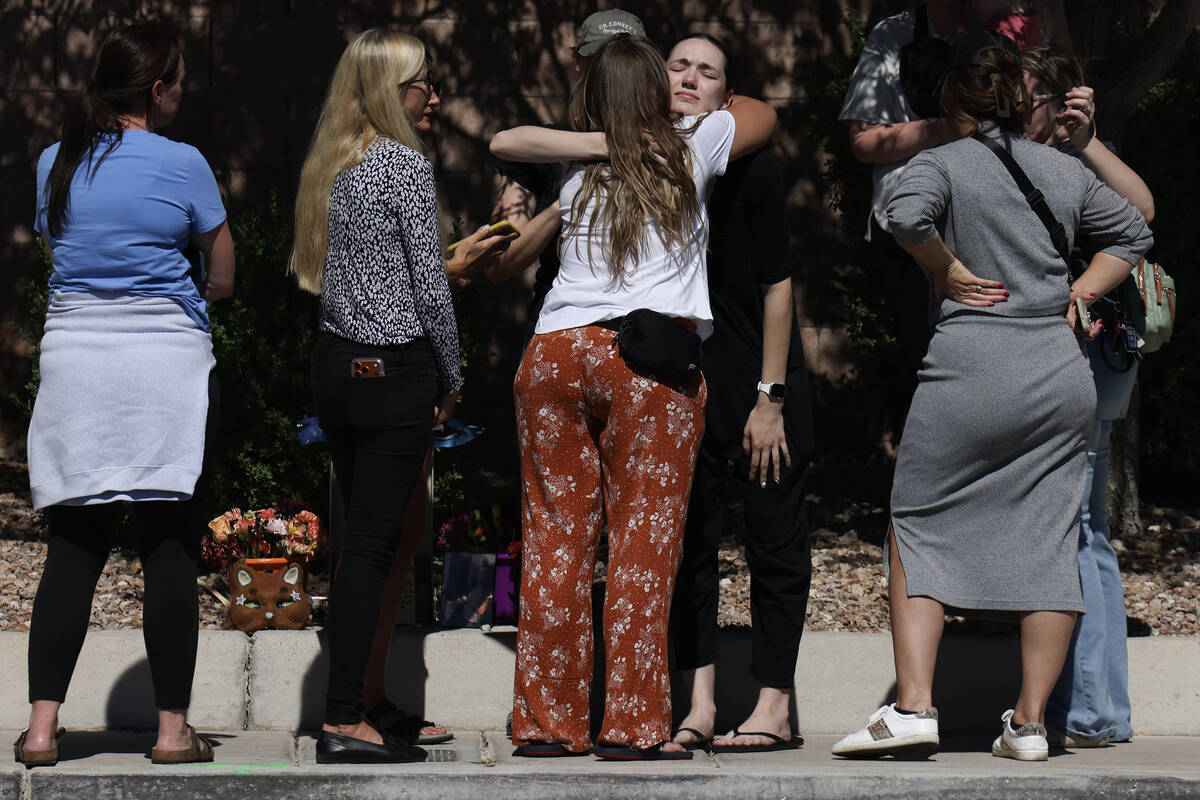 Family and friends comfort each other on West Tropical Parkway west of North Emerald Eagle Stre ...