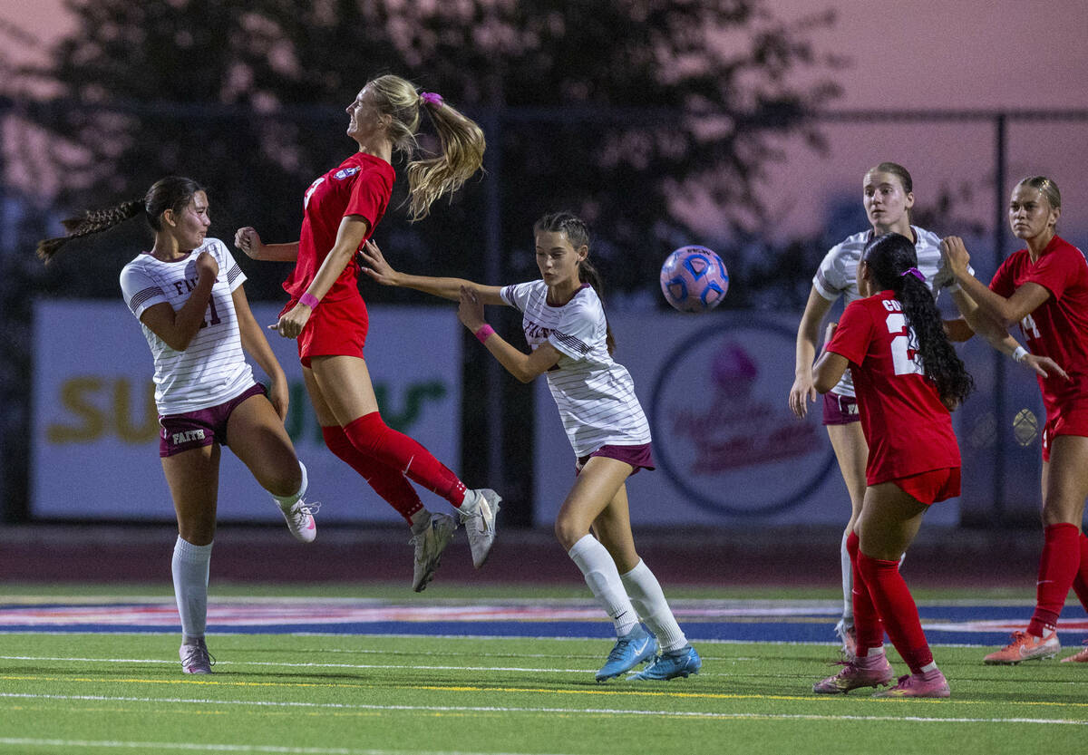 Coronado's Alexandra Milano (3) heads the ball past Faith Lutheran's Ana Coe (11) and ...