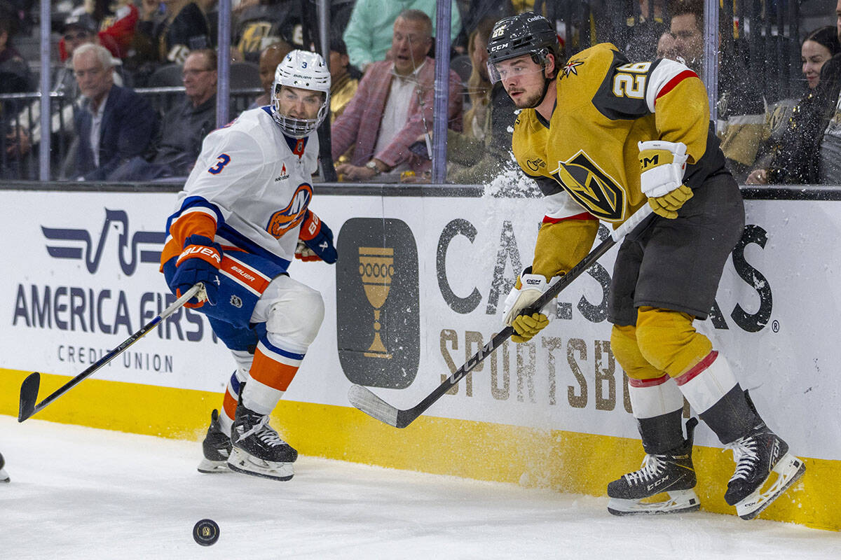 Golden Knights right wing Alexander Holtz (26) and New York Islanders defenseman Adam Pelech (3 ...