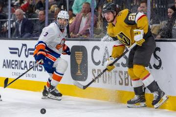 Golden Knights right wing Alexander Holtz (26) and New York Islanders defenseman Adam Pelech (3 ...