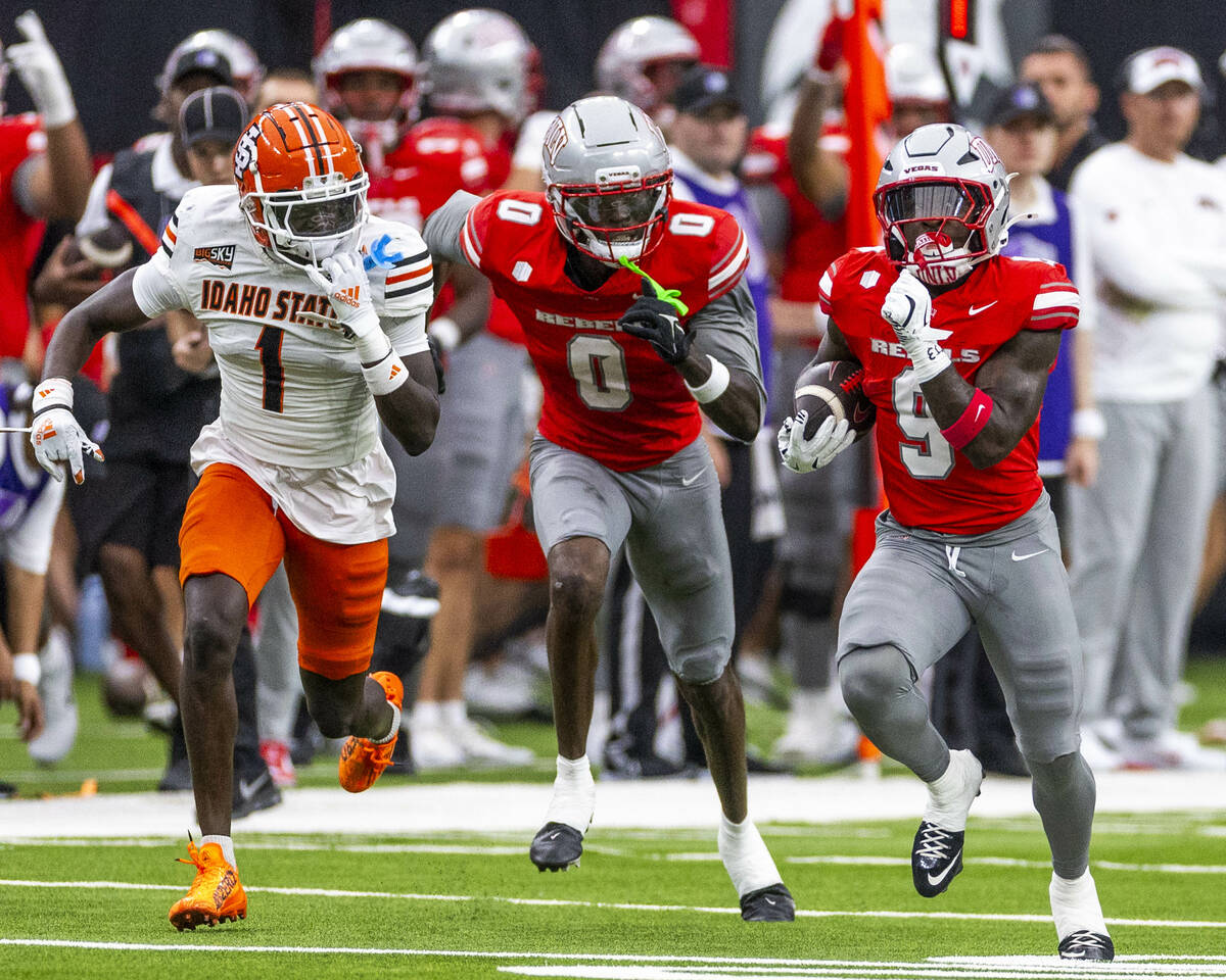 UNLV running back Jai'Den Thomas (9) runs to the end zone as wide receiver Troy Omeire (0) ...