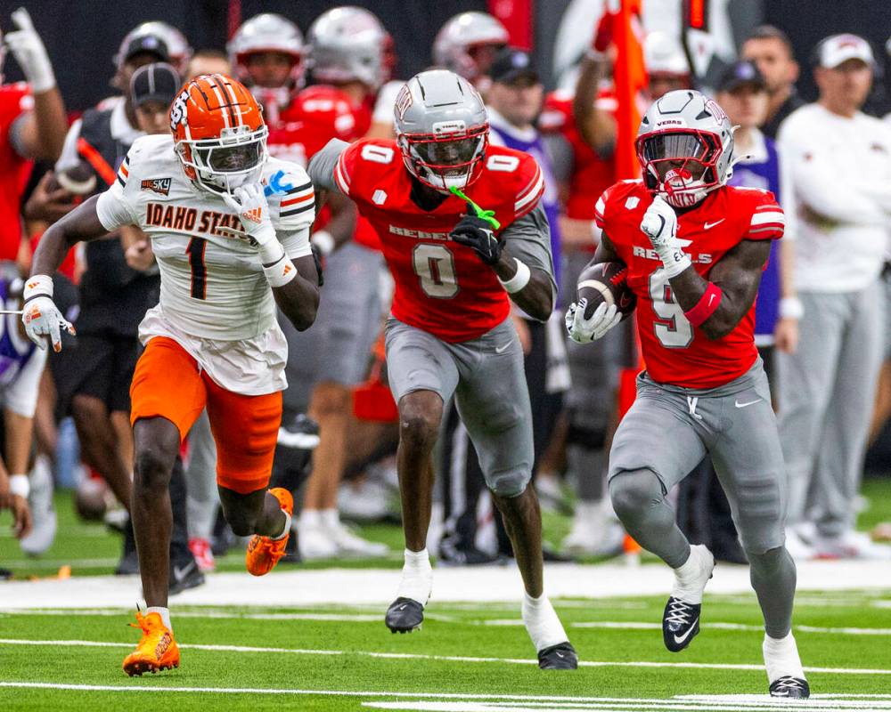 UNLV running back Jai'Den Thomas (9) runs to the end zone as wide receiver Troy Omeire (0) ...