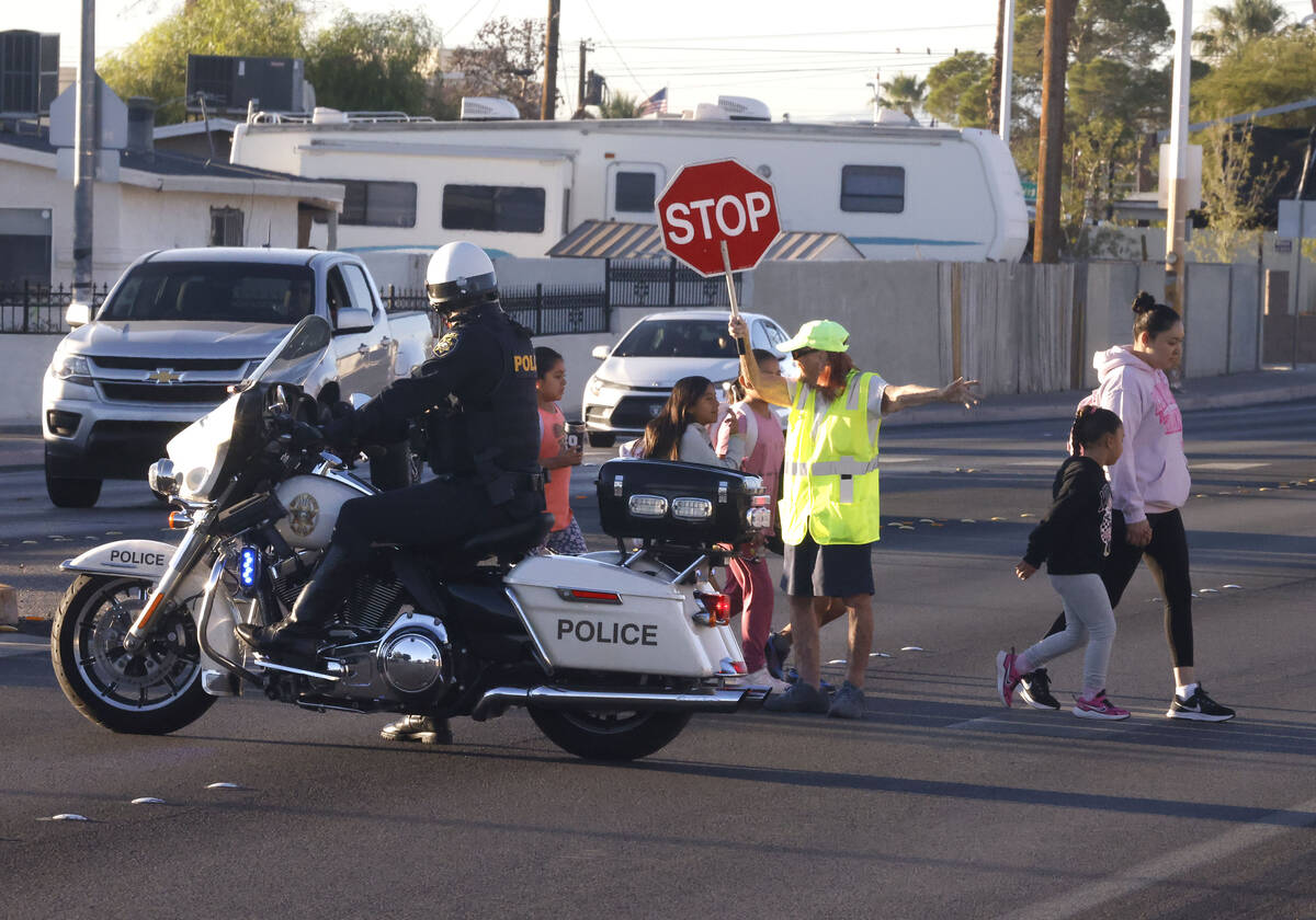 Parents and children cross Torrey Pines Drive as they participate in the annual Walk & Roll ...