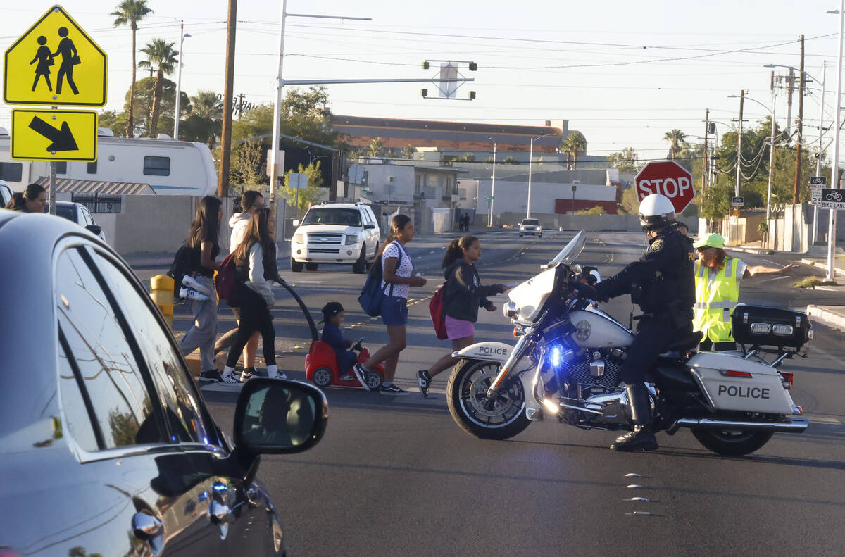 Parents and children cross Torrey Pines Drive as they participate in the annual Walk & Roll ...