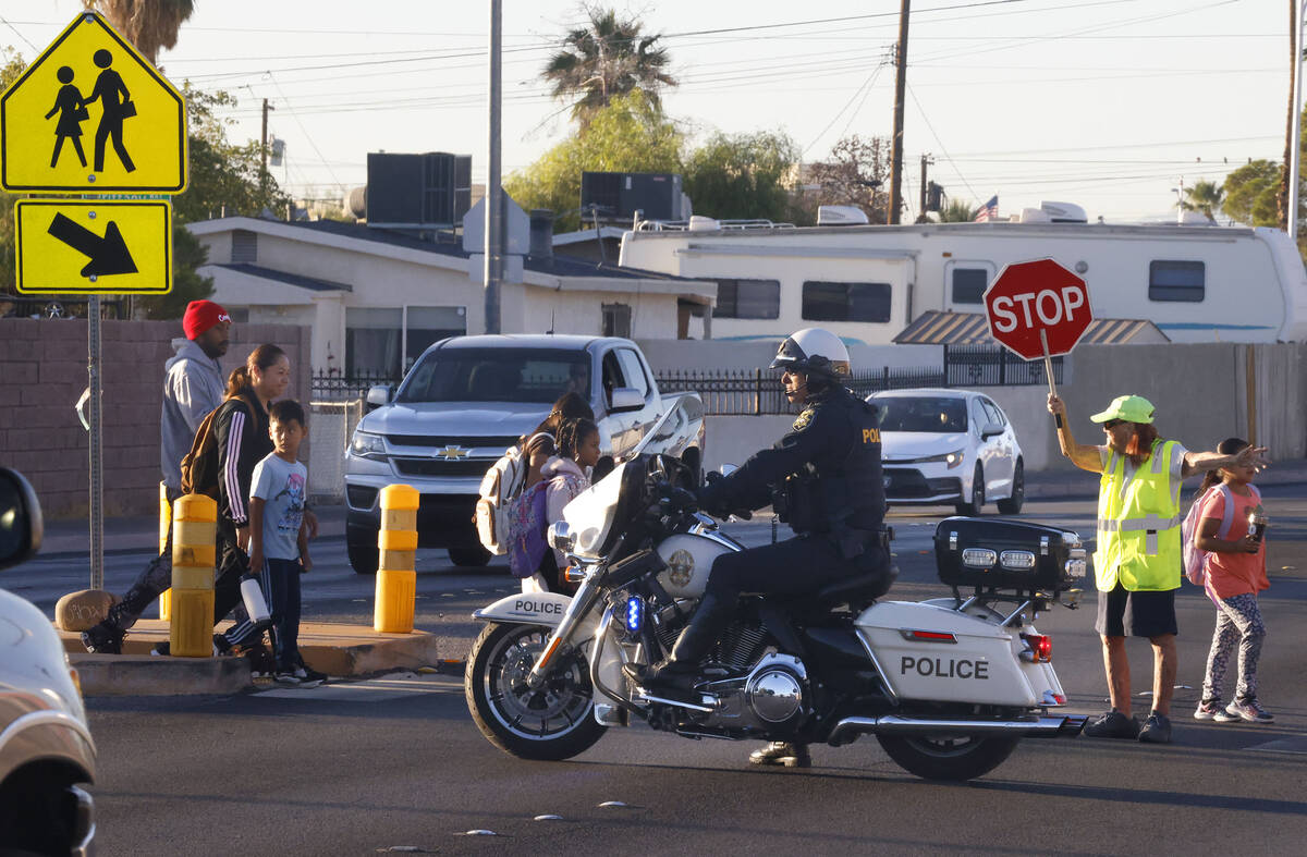 Parents and children cross Torrey Pines Drive as they participate in the annual Walk & Roll ...