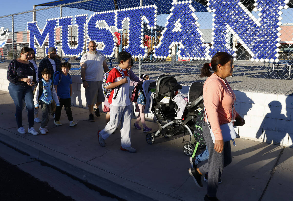 Parents and children walk on a sidewalk along Torrey Pines Drive as they participate in the ann ...