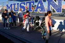 Parents and children walk on a sidewalk along Torrey Pines Drive as they participate in the ann ...