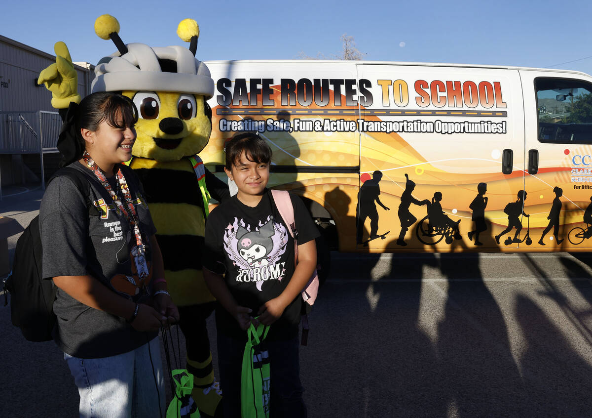 Katie Ramirez-Perez, left, 11, and her sister Juliet, 8, pose for photo with Bee Safe mascot af ...