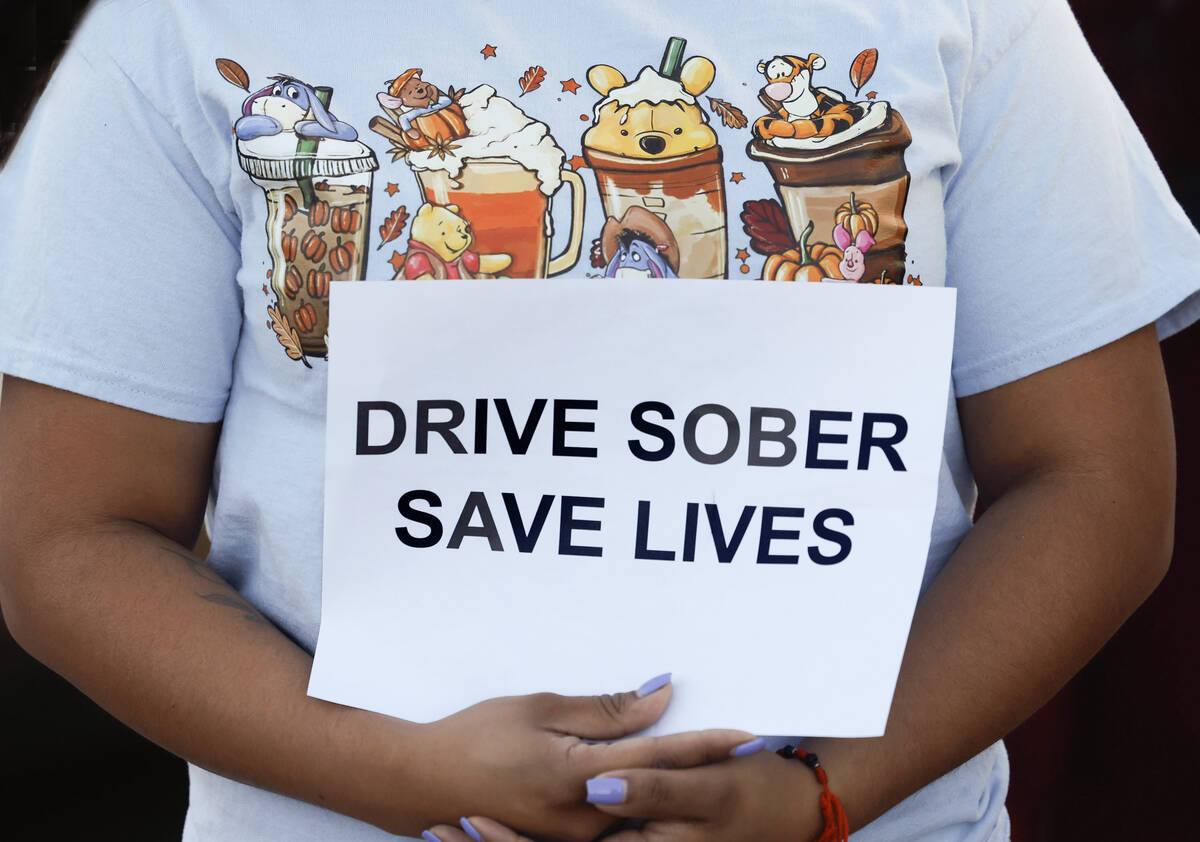 Veronica Garcia holds a sign as she joins parents and students from Smith Middle School, who ga ...