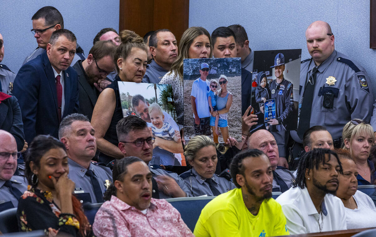 Supporters hold family photos of the Abbate family as Jemarcus Williams, who pleaded guilty in ...