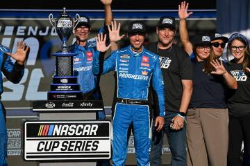 Denny Hamlin, center, celebrates after winning a NASCAR Cup Series auto race at World Wide Tech ...