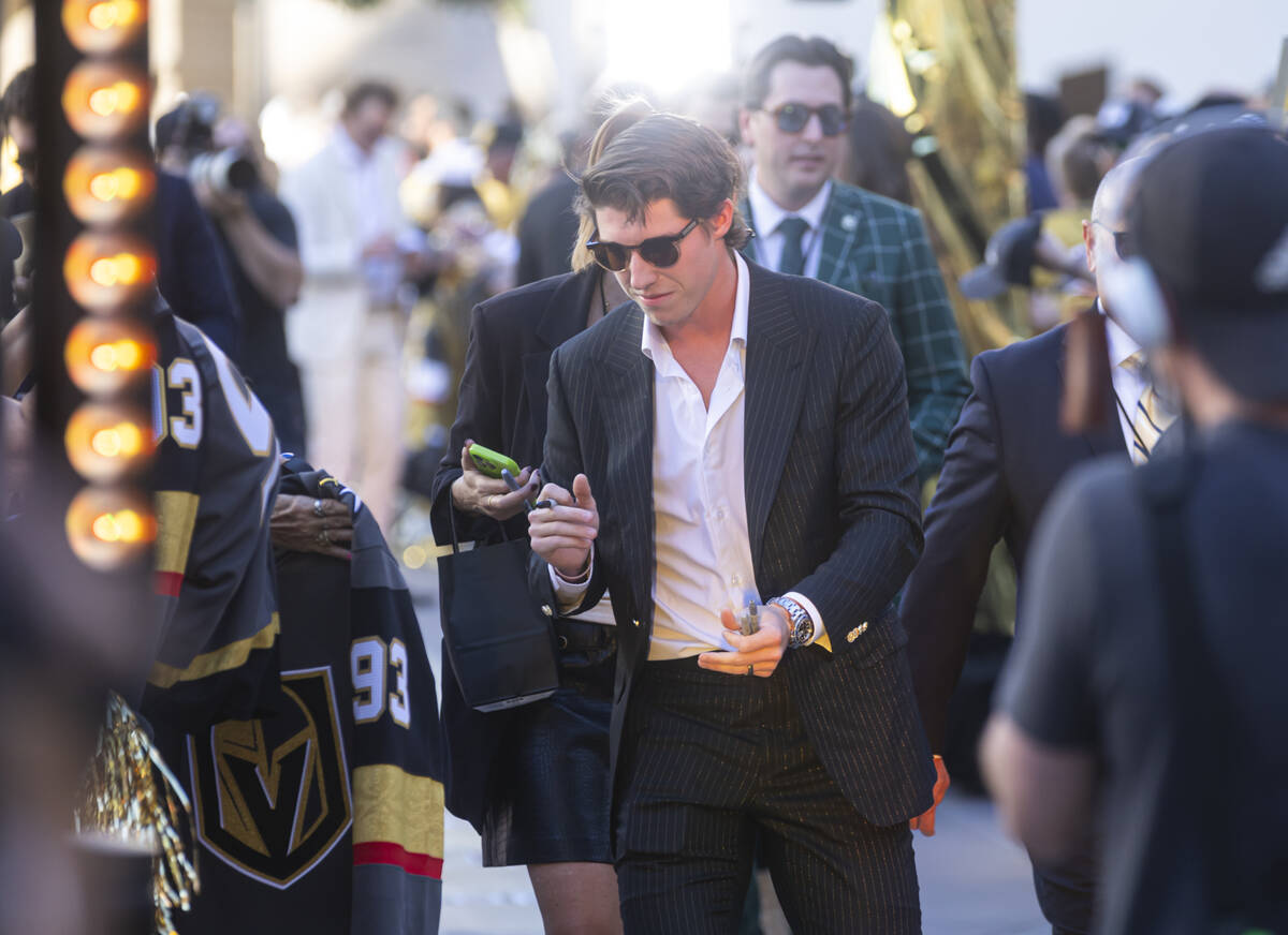Golden Knights right wing Mitch Marner signs items for fans while walking the gold carpet ahead ...