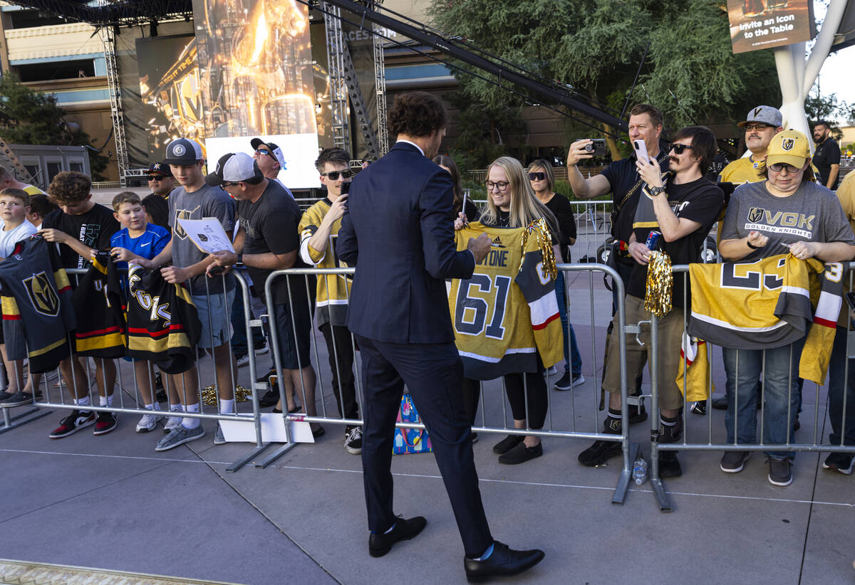 Golden Knights right wing Mark Stone (61) signs items for fans while walking the gold carpet ah ...